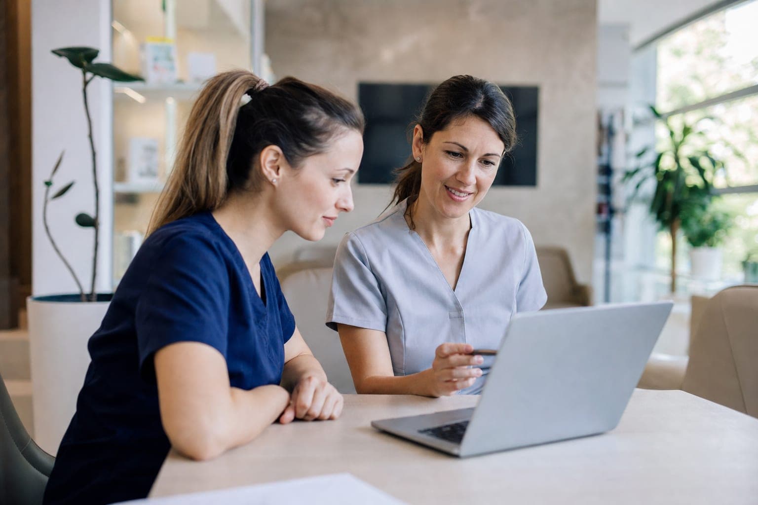 Zwei Personen im Büro besprechen am Laptop die offene Stelle
